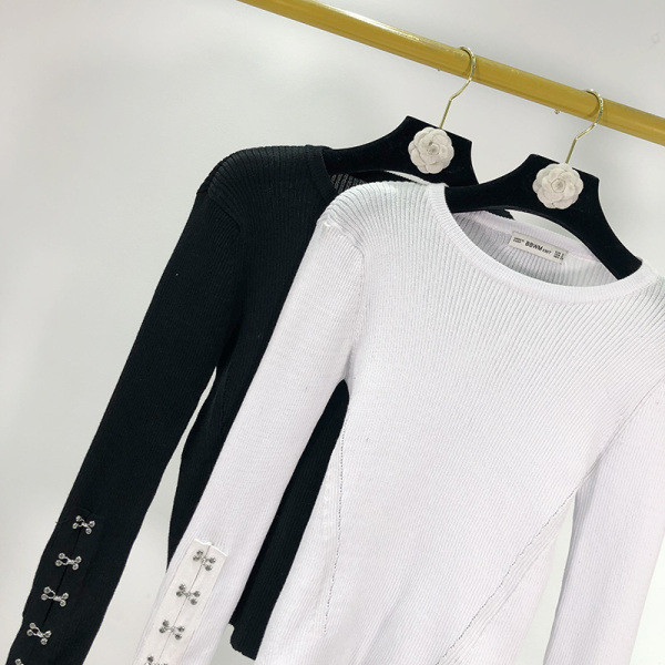 Női testhezálló blúz ovális nyakkivágással és fém elemekkel fehér és fekete színben