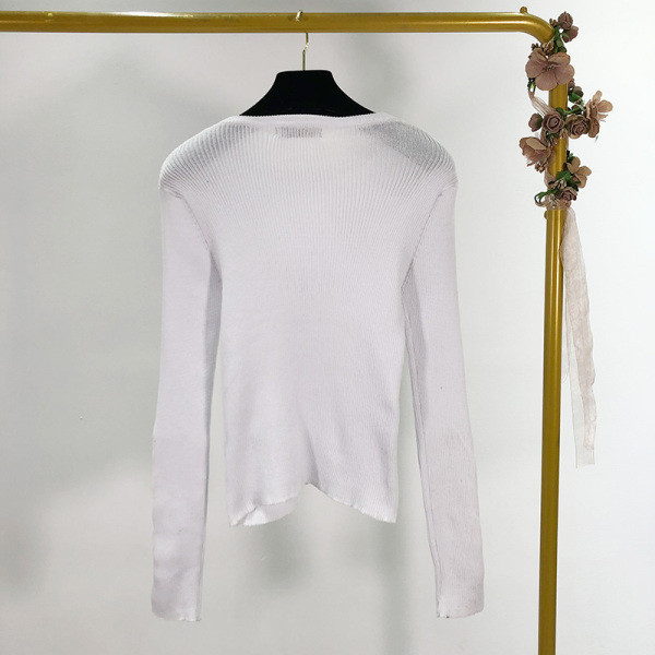 Női testhezálló blúz ovális nyakkivágással és fém elemekkel fehér és fekete színben