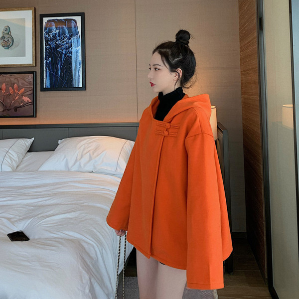 Rövid, széles női kabát kapucnival, aszimmetrikus rögzítéssel