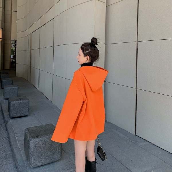 Rövid, széles női kabát kapucnival, aszimmetrikus rögzítéssel