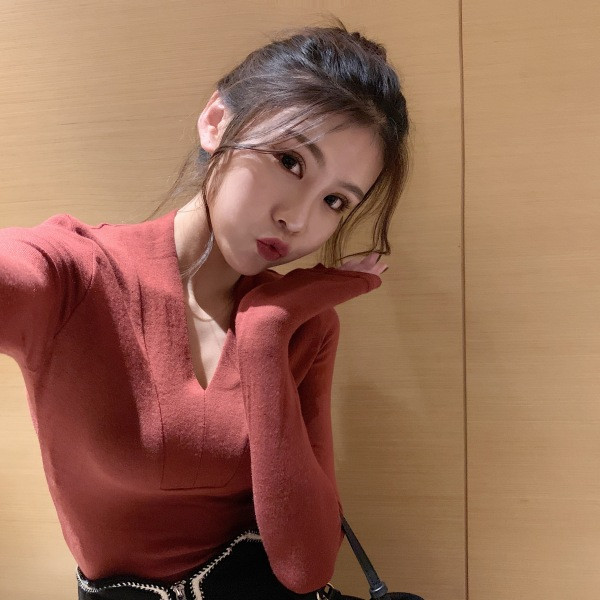 Vékony kötésből készült női testhezálló blúz spitz nyakkivágással