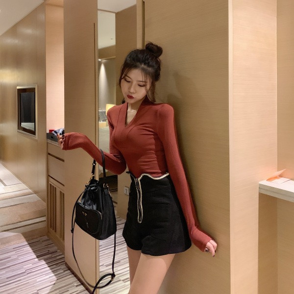 Vékony kötésből készült női testhezálló blúz spitz nyakkivágással