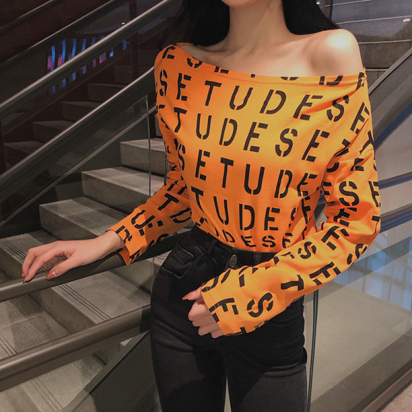 Női testhezálló blúz fekete, fehér és narancssárga feliratokkal