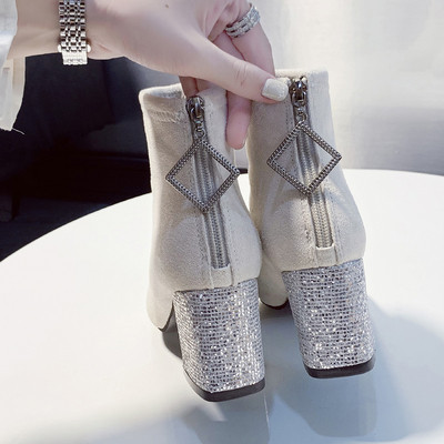 Κομψές γυναικείες μπότες με φερμουάρ και γυαλιστερό τακούνι σε λευκό και μαύρο χρώμα