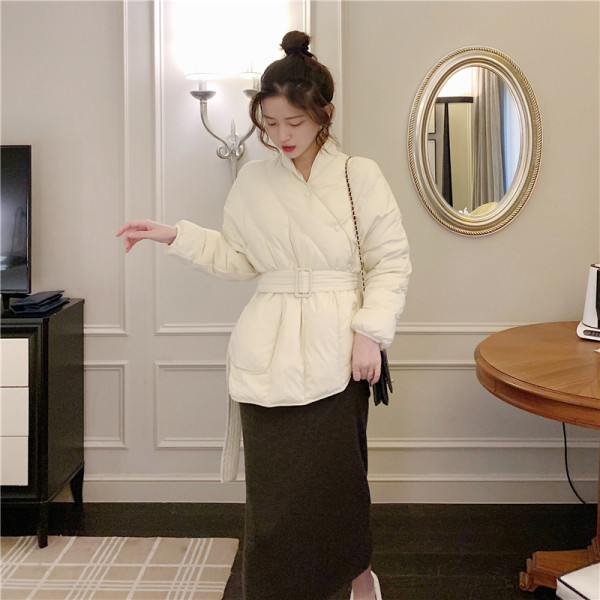 Női téli kabát aszimmetrikus rögzítéssel és övvel