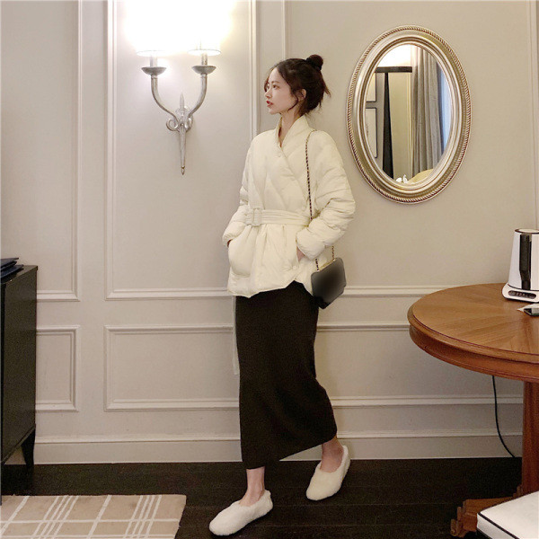 Női téli kabát aszimmetrikus rögzítéssel és övvel