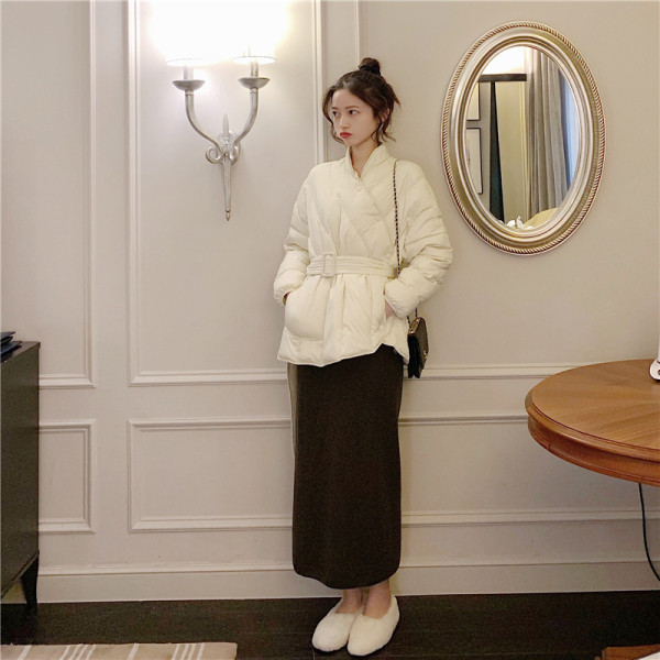 Női téli kabát aszimmetrikus rögzítéssel és övvel