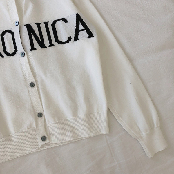 Modern mellény gombokkal és fekete-fehér felirattal