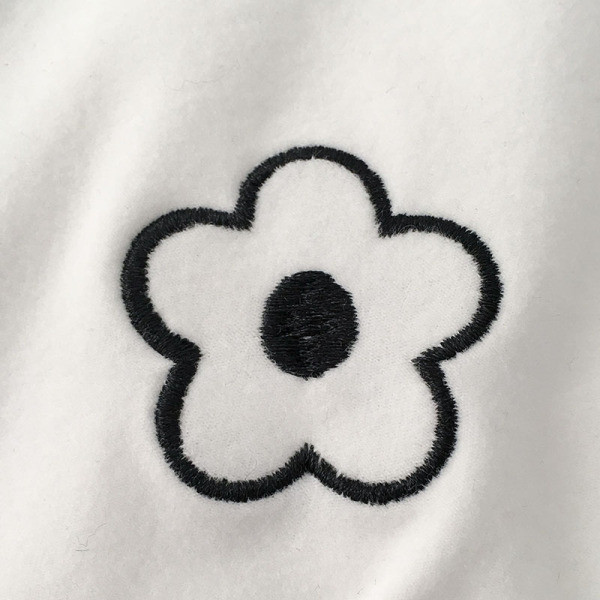 Modern női blúz fekete-fehér színben, magas gallérral és hímzéssel