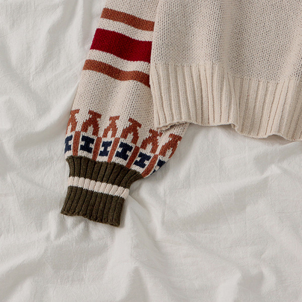 Modern női pulóver ovális nyakkivágással, színes mintával fehér és fekete színben