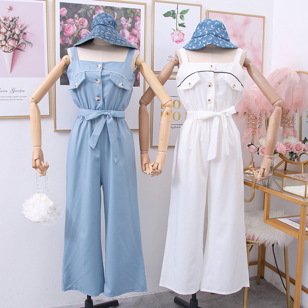 Modern női jumpsuit pántokkal, gombokkal és övvel fehér, fekete és kék színben