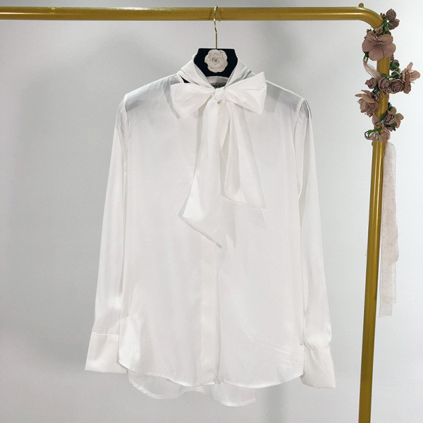 Modern női ing gombokkal és szalaggal a nyakkivágáson, fehér színben