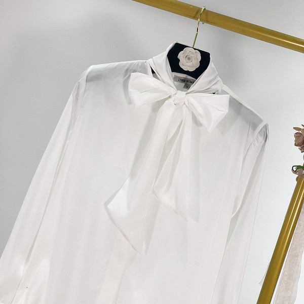 Modern női ing gombokkal és szalaggal a nyakkivágáson, fehér színben