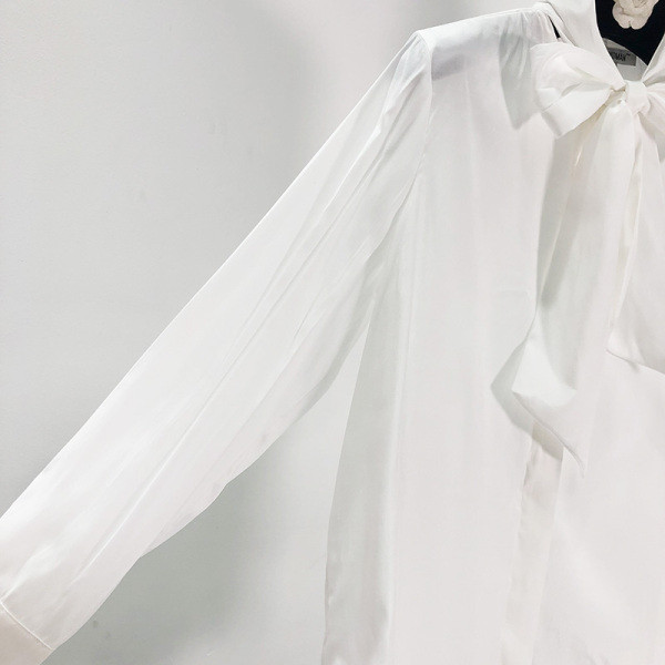 Modern női ing gombokkal és szalaggal a nyakkivágáson, fehér színben