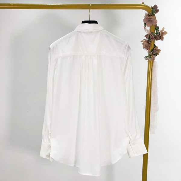 Modern női ing gombokkal és szalaggal a nyakkivágáson, fehér színben