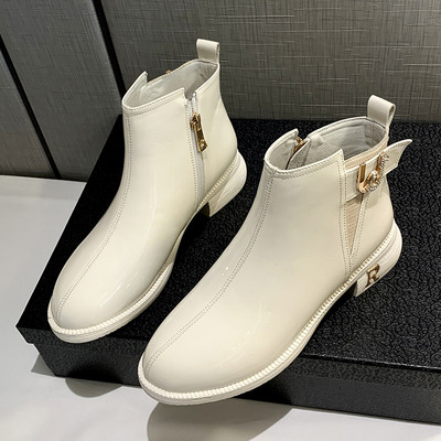 Μοντέρνες γυναικείες μπότες με επίπεδη σόλα και μεταλλικό στοιχείο σε μαύρο και άσπρο χρώμα