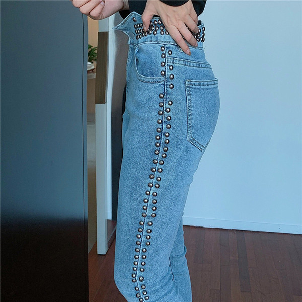 Hosszú fazonú, világos színű farmer, fém lyukakkal