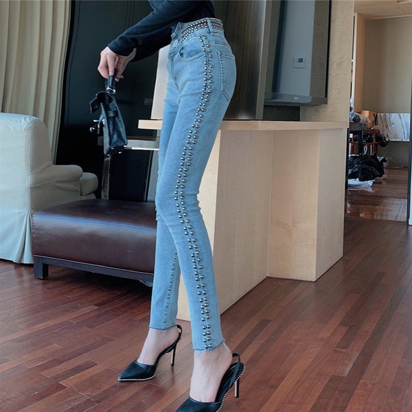 Hosszú fazonú, világos színű farmer, fém lyukakkal