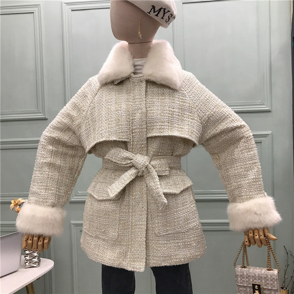 Modern női kabát puha gallérral, zsebekkel és övvel fehér és fekete színben