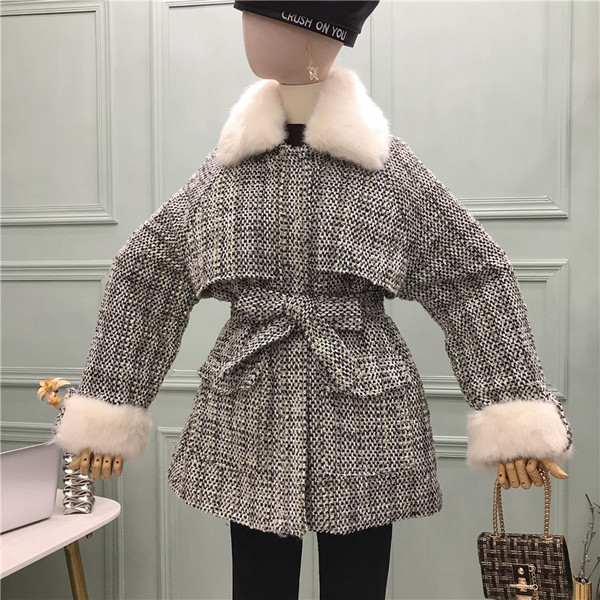 Modern női kabát puha gallérral, zsebekkel és övvel fehér és fekete színben