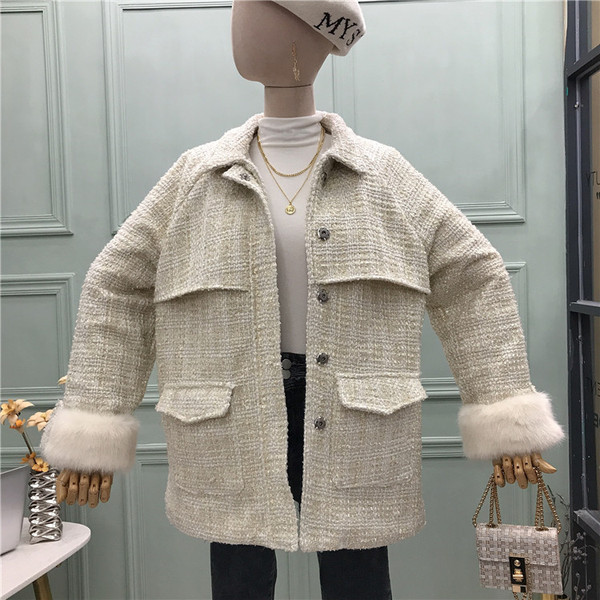 Modern női kabát puha gallérral, zsebekkel és övvel fehér és fekete színben