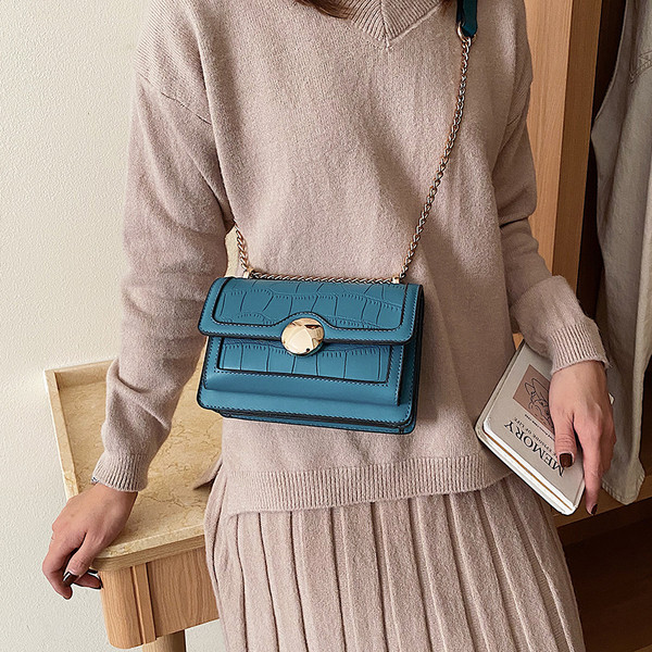 Női bőrtáska lánccal és fém csattal