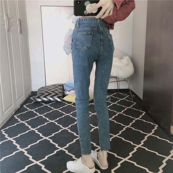 Kék színű, testhezálló női farmer övvel és magas derékkal