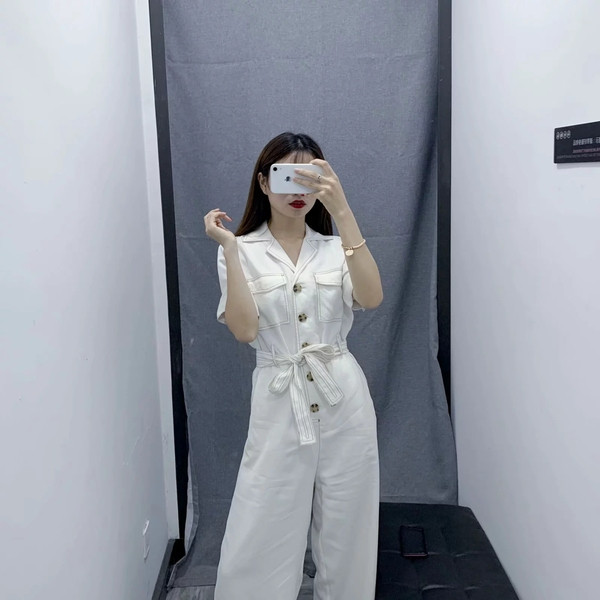 Salopetă casual de damă cu mâneci scurte de culoare albă, cu curea și buzunare