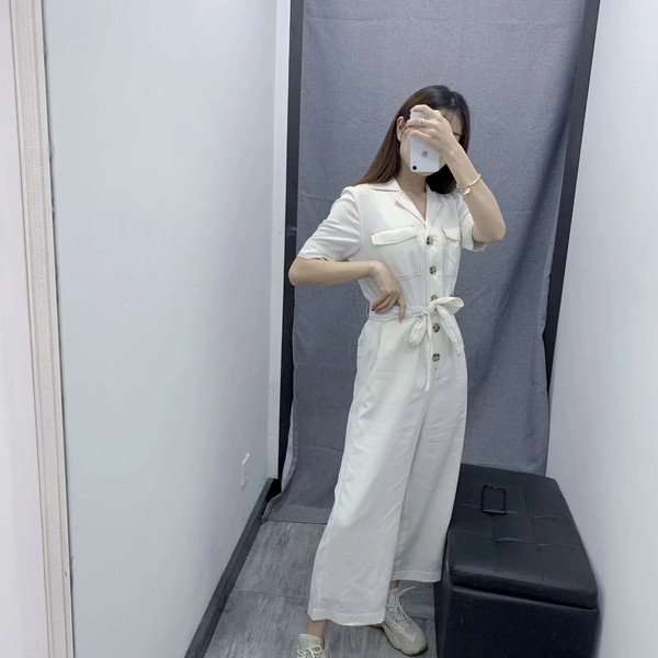 Salopetă casual de damă cu mâneci scurte de culoare albă, cu curea și buzunare