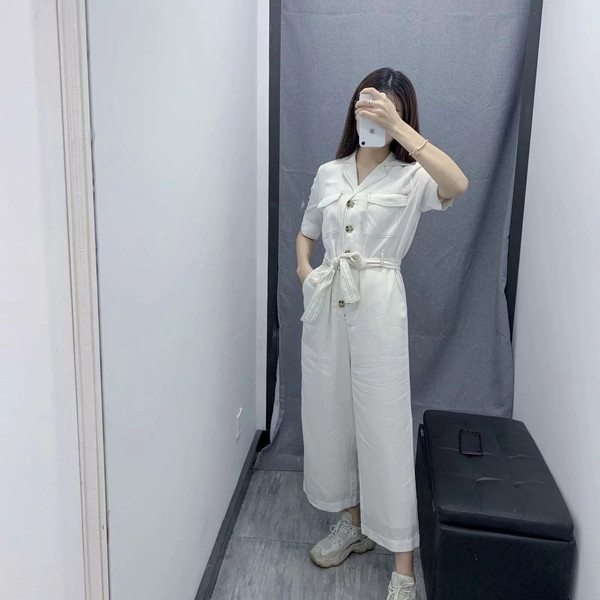 Salopetă casual de damă cu mâneci scurte de culoare albă, cu curea și buzunare