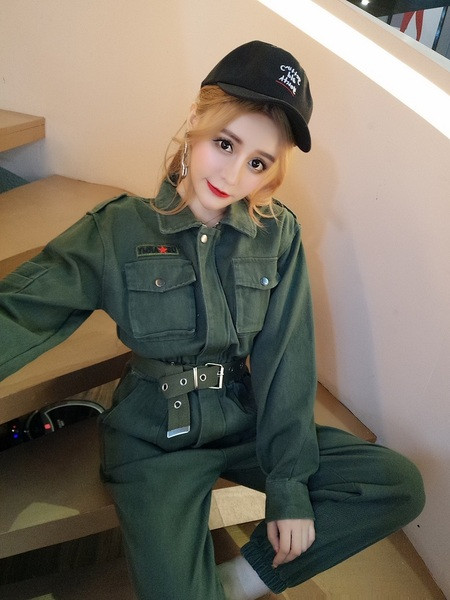 Modern női overál klasszikus gallérral és zsebekkel, övvel és a bokánál zöld színű gumival