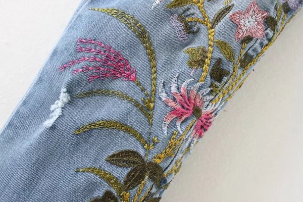 Modern hosszú farmernadrág kék színben virágos hímzéssel és szakadt motívummal