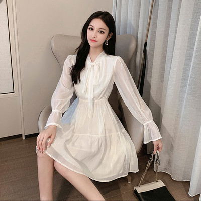 Modern, fehér szabású női ruhamodell, hosszú ujjal és nyakkendővel