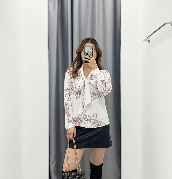 Alkalmi női blúz nyakkivágással szalaggal, fehér színben, színes mintával