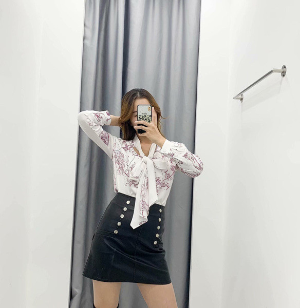 Alkalmi női blúz nyakkivágással szalaggal, fehér színben, színes mintával