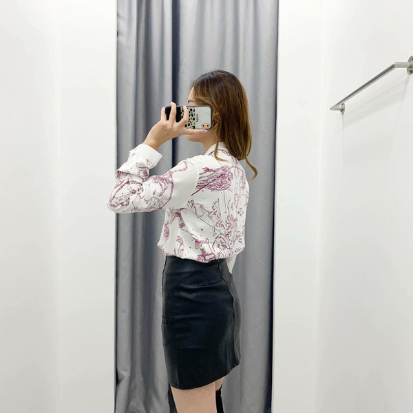 Alkalmi női blúz nyakkivágással szalaggal, fehér színben, színes mintával