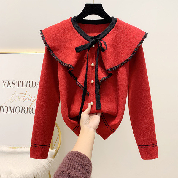 Női pulóver gallérján szalaggal, piros, fekete és fehér gyöngyökkel