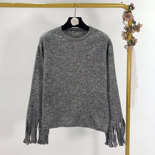 Szürke színű, széles női pulóver ovális nyakkivágással, ujjain rojtokkal