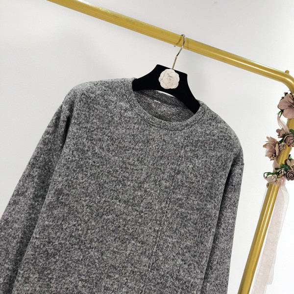 Szürke színű, széles női pulóver ovális nyakkivágással, ujjain rojtokkal