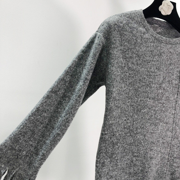 Szürke színű, széles női pulóver ovális nyakkivágással, ujjain rojtokkal