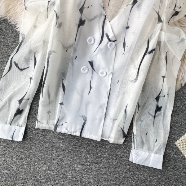 Modern női ing gombokkal és spitz nyakkivágással, fehér színben színes nyomattal