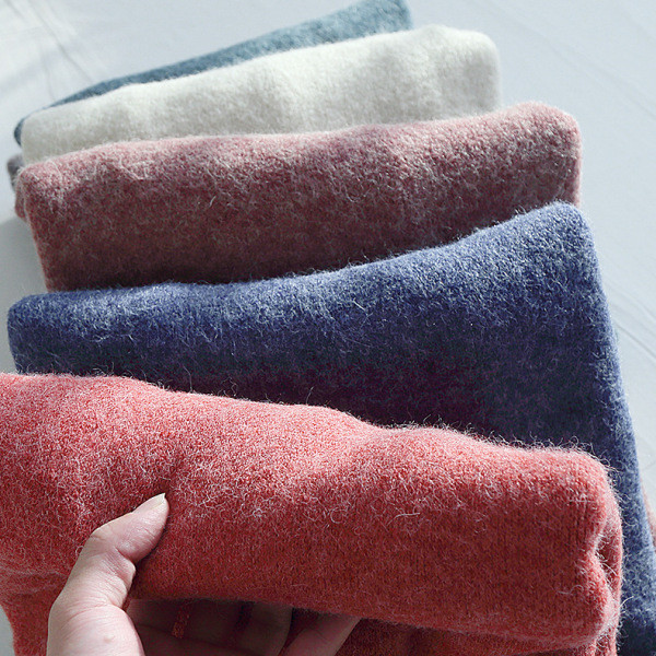 Női téli blúz kerek nyakkivágással és aszimmetrikus hasítékos mintával