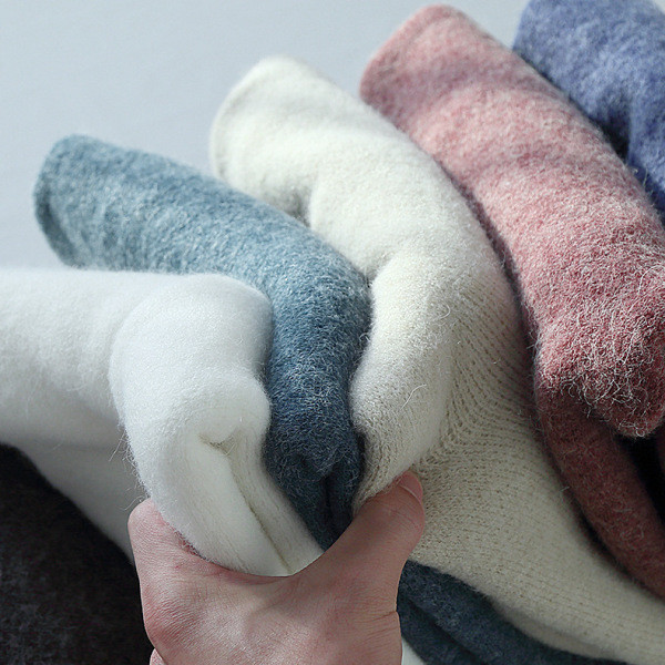 Női téli blúz kerek nyakkivágással és aszimmetrikus hasítékos mintával