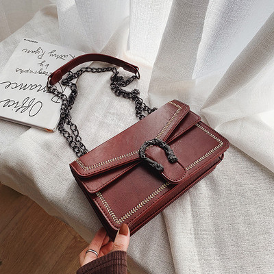 Öko bőrből készült női táska fém elemmel és lánccal fekete, bordó és piros színben