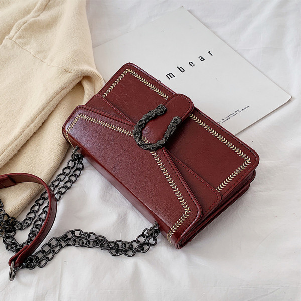 Öko bőrből készült női táska fém elemmel és lánccal fekete, bordó és piros színben