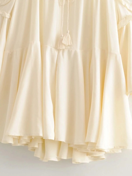 Női felső kivágású modell vékony pántokkal és fürtökkel, bézs színben