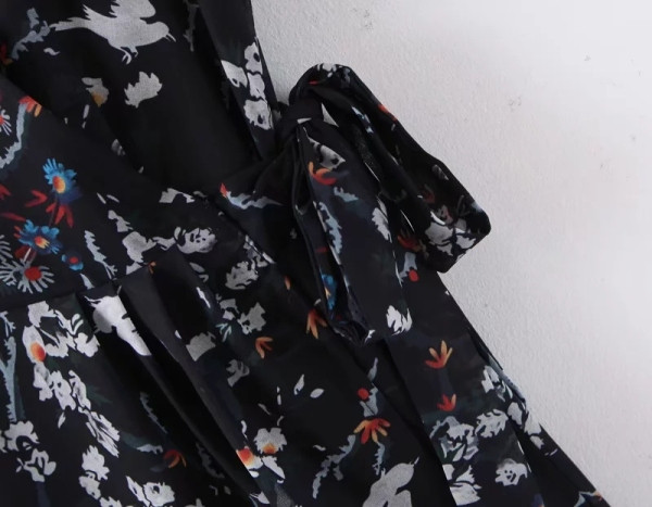 Lezser kivágott női ruhamodell mély V-nyakkal és derékkötővel, fekete és virágmintás