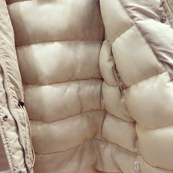 Stílusos női téli kabát derékcsatlakozással és hímzéssel az ujjain fekete és bézs színben