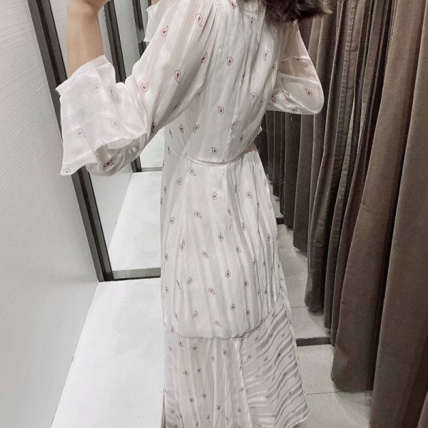 Kivágott aszimmetrikus női ruha fürtökkel és mély dekoltázssal, fehér színben