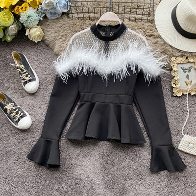 Μοντέρνα γυναικεία μπλούζα σε λευκό και μαύρο χρώμα με στρογγυλή λαιμόκοψη και φούντες